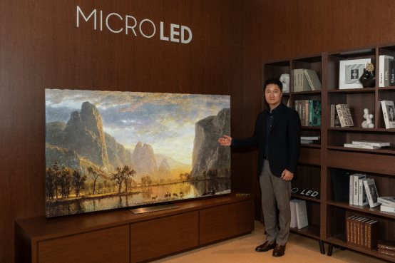 A person standing in front of a large paintingDes<i></i>cription automatically generated